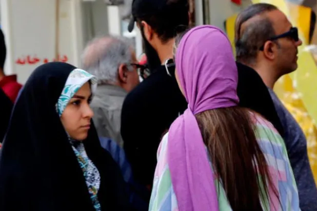 دو ایرانی خواتین کو کل وسطی تہران میں ایک گلی سے گزرتے ہوئے دیکھا جا سکتا ہے (اے پی اے)