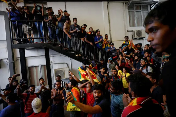 المتظاهرون يحتفلون عقب اقتحامهم مبنى مكتب رئيس الوزراء السريلانكي رانيل ويكريمسينغه (رويترز)