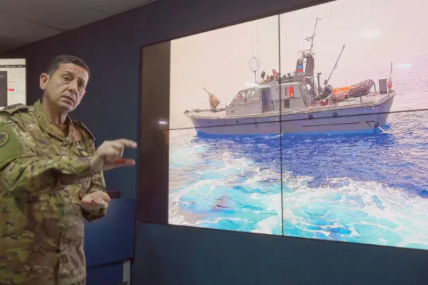 ضابط لبناني يعرض للصحافيين محاولة إحدى سفنه الحربية إنقاذ ضحايا المركب في أبريل الماضي (إ.ب.أ)