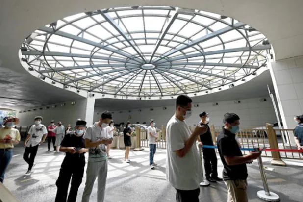 أشخاص يصطفون في طابور لإجراء اختبار لفيروس كورونا في بكين أول من أمس (أ.ف.ب)