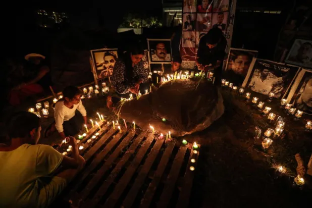 متظاهرون يشعلون الشموع لذكرى آخرين قتلوا خلال الاحتجاجات التي استمرت لأشهر في كولومبو (إ.ب.أ)