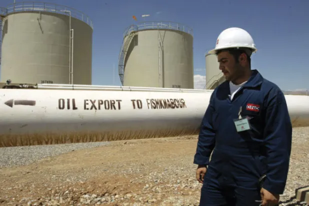 عامل في مصفاة تاوكي للنفط بالقرب من قرية زاتشو في إقليم كردستان العراق المتمتع بالحكم الذاتي (أ.ف.ب)