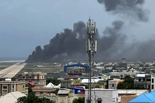 دخان يتصاعد من طائرة انقلبت بعد هبوطها في مطار العاصمة مقديشو أمس (رويترز)