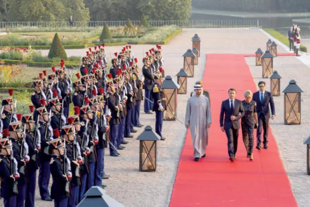 الشيخ محمد بن زايد آل نهيان مع الرئيس الفرنسي وزوجته في طريقهم إلى حفل العشاء بغراند تريانون في فرساي أول من أمس (أ.ف.ب)