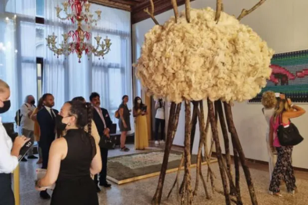 نمائش میں آنے والے زائرین مصور خلود البقمی  کے "سفر" کے کام پر غور کر رہے ہیں (اشرق الاوسط)