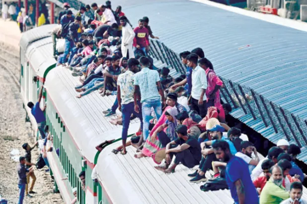 يؤدي جلوس المسافرين على أسطح القطارات إلى الموت بسبب سقوطهم أو اصطدامهم بفروع الأشجار المتدلية أو الجسور المنخفضة (أ.ف.ب)