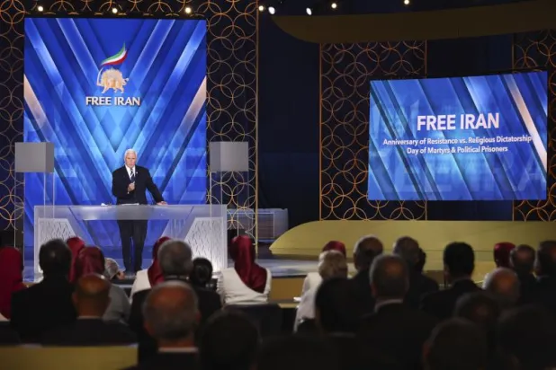 بنس يتحدث في مقر المعارضة الإيرانية بمعسكر «أشرف 3» غرب تيرانا الألبانية يونيو الماضي (أ.ب)