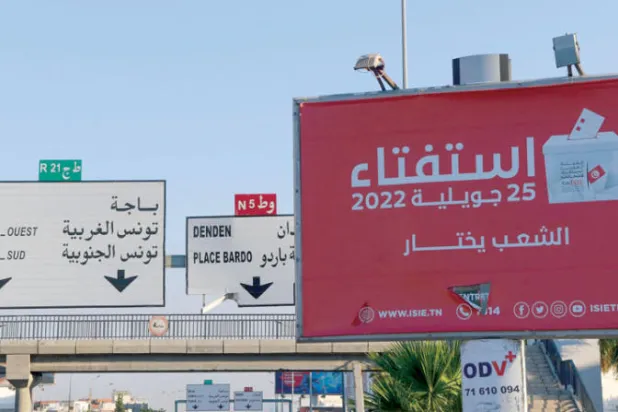 لوحة للتشجيع على المشاركة في الاستفتاء في أحد شوارع العاصمة التونسية (أ.ف.ب)
