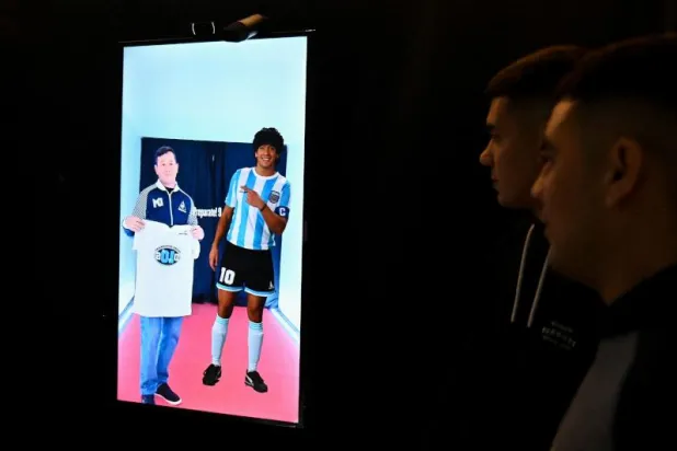 مشجعون للنجم الأرجنتيني الراحل دييغو مارادونا في القاعدة الجوية «دي مورون» حيث يجري تسجيل الرسائل له (أ.ف.ب)