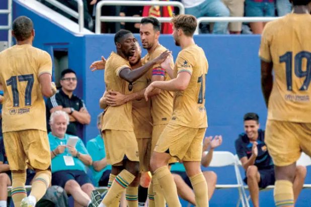 لاعبو برشلونة يحتفلون بأحد أهدافهم ضمن معسكرهم الصيفي (أ.ب)