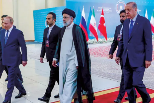 رئيسي مستقبلاً ضيفيه إردوغان (يمين) وبوتين في طهران (أ.ف.ب)