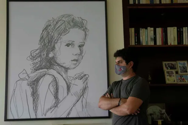 Paul Naggear, stands next a portrait of his daughter Alexandra, who was killed in 2020 massive blast at Beirut's seaport, during an interview in the town of Beit Mery in the hills east of Beirut, Lebanon, Tuesday, July 12, 2022. (AP Photo/Hassan Ammar)