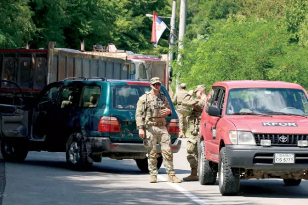 جنود أميركيون من قوة «كوفور» التابعة لـ«الناتو» عند نقطة حدودية في كوسوفو أمس (رويترز)