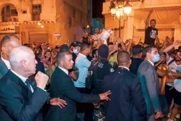 الرئيس قيس سعيّد (يسار) يحتفل مع مناصريه بالفوز بالاستفتاء على الدستور الجديد في تونس يوليو الماضي (إ.ب.أ)