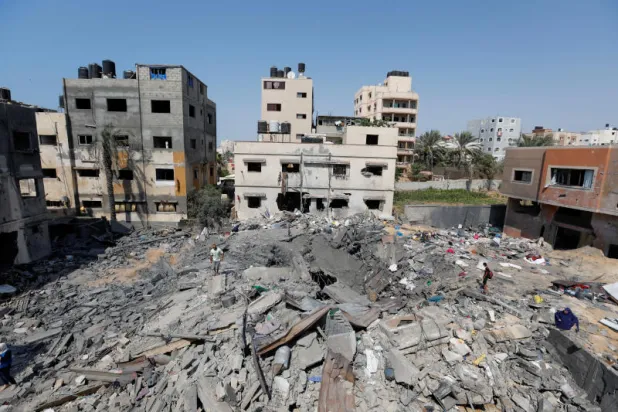 فلسطينيون بين ما بقي من منزل في غزة دمره القصف الإسرائيلي (رويترز)