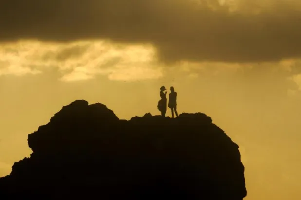 مصريان على أحد شواطئ مدينة مرسى مطروح الشاطئية على البحر المتوسط (أ.ب)