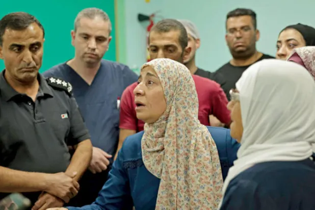 والدة الفلسطيني مؤمن ياسين جابر في ذهول إثر وفاة ابنها في مستشفى بالخليل في 9 أغسطس على يد القوات الإسرائيلية (أ.ف.ب)