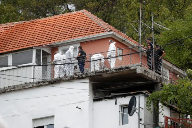 فريق الطب الشرعي التابع للشرطة يتفقد المنزل الذي بدأ فيه مسلح إطلاق نار جماعي في سيتينيي بمونتينيغرو (رويترز)