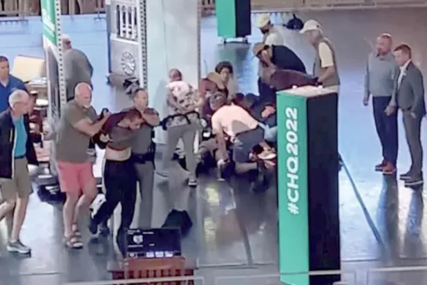 ویڈیو ٹیپ کی ایک تصویر جس میں دو افراد ہادی مطر کو پکڑے ہوئے ہیں جبکہ دوسرے لوگ سلمان رشدی کو چاقو مارے جانے کے بعد ان کی دیکھ بھال کر رہے ہیں (اے پی)