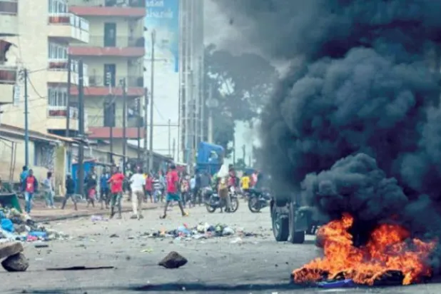 Gine’nin başkenti Konakri’de yolları trafiğe kapatan göstericiler, güvenlik güçlerine taş atıyor (AFP)