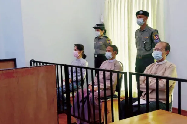 أونغ سان سو تشي كما ظهرت في المحكمة مع اثنين من اتباعها أمس (أ.ف.ب)