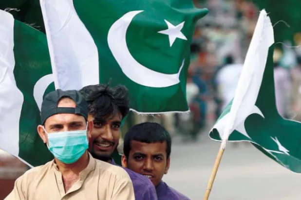 Pakistanlılar önceki gün Bağımsızlık Günü kutlamalarında milli bayraklarını taşıyor (AFP)