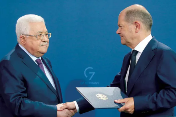 مصافحة بين المستشار الألماني والرئيس الفلسطيني بعد مؤتمر صحافي في برلين الثلاثاء (د.ب.أ)