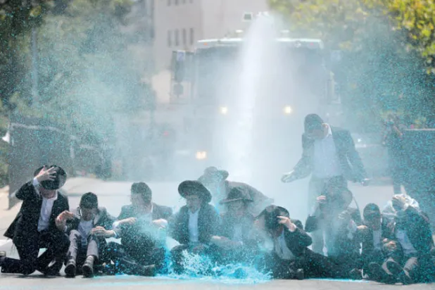 شرطة تستخدم خراطيم المياه لتفريق المتظاهرين اليهود الأرثوذكس المتطرفين في حي ديني بالقدس يوم الاثنين (إ.ب.أ)