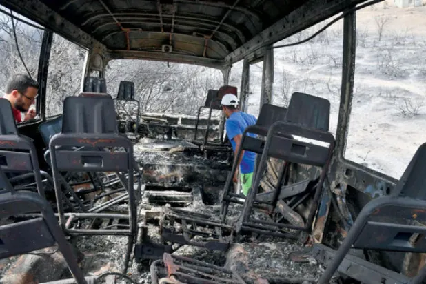 بقايا حافلة بعد احتراقها في ولاية الطارف أمس (أ.ف.ب)