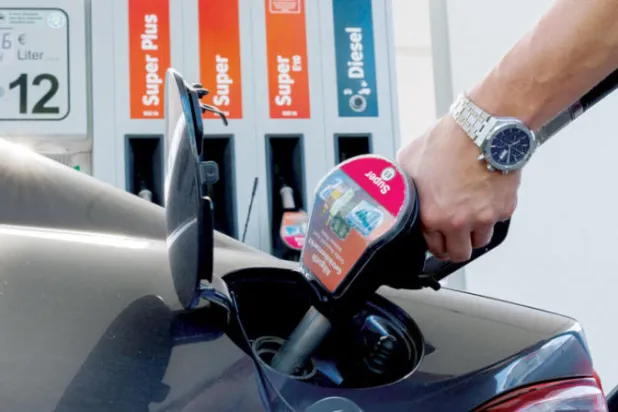 سائق سيارة يعيد تزويد سيارته بالوقود في محطة وقود في ميونيخ (رويترز)