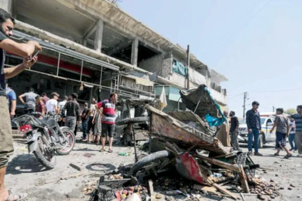 گزشتہ روز شمالی شام کے حلب گورنریٹ کے الباب شہر میں میزائل حملے کی جگہ پر رہائشیوں کو دیکھا جا سکتا ہے (اے ایف پی)