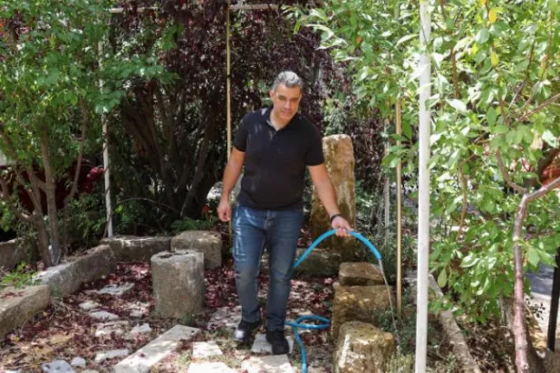 ولید الشعار کارمند وزارت دارایی به باغچه اش آب می دهد (رویترز)