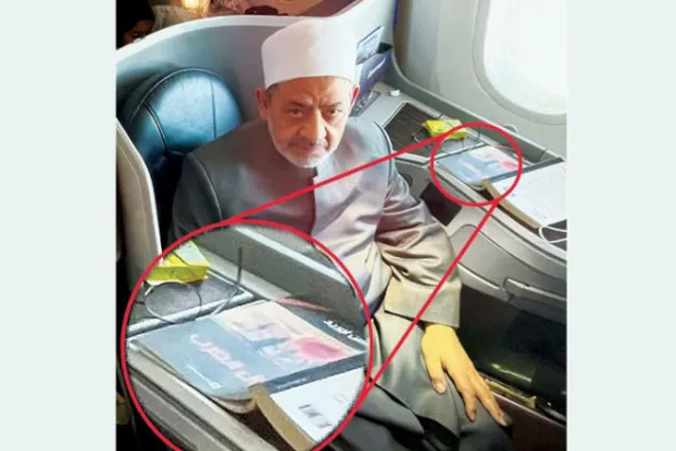شيخ الأزهر أحمد الطيب على متن رحلة جوية وفي الإطار صورة مكبرة لكتاب «أفول الغرب» (تويتر)