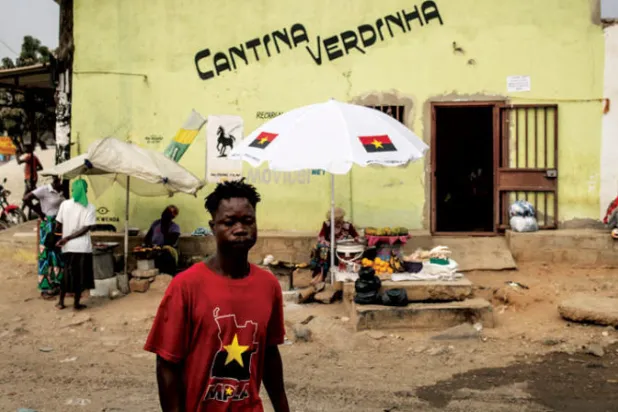 أنغولي يرتدي قميص الحركة الشعبية استعداداً للانتخابات (أ.ف.ب)