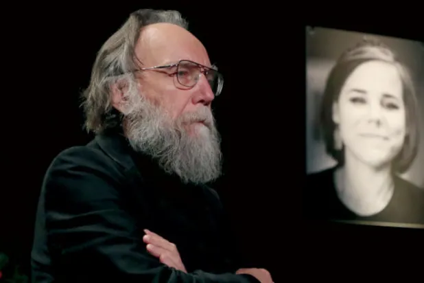 ألكسندر دوغين مع صورة لابنته خلال مراسم تشييعها في موسكو (إ.ب.أ)