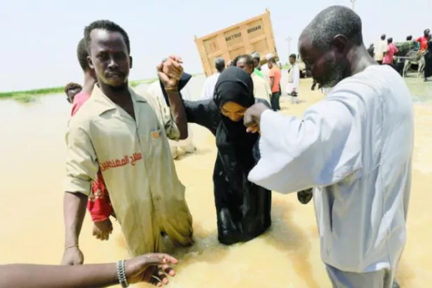 سوڈانیوں کو الجزیرہ ریاست کے المناقل علاقے میں سیلاب زدہ علاقے کو عبور کرنے کی کوشش کرتے ہوئے دیکھا جا سکتا ہے (رائٹرز)