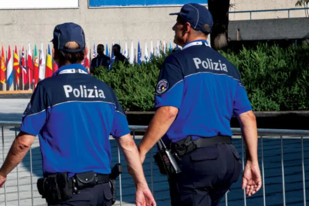 ضباط شرطة سويسريون يسيرون أمام مركز المؤتمرات في لوغانو (رويترز)