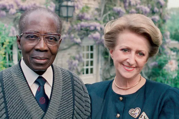 سنغور وزوجته في لقطة أرشيفية بحديقة منزلهما في فيرسون شمال غربي فرنسا (أ.ف.ب)