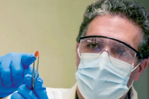 البروفسور خالد سلامة يحمل مصفوفة مستقبلات ضوئية مرنة مصنعة في {كاوست}
