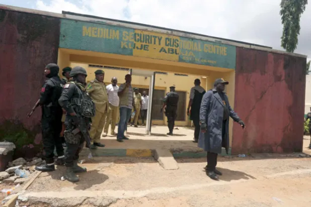 مسؤولون خارج سجن كوجي للحراسة المتوسطة في أبوجا بعد أن هاجم مسلحون السجن في يوليو الماضي (أ.ف.ب)