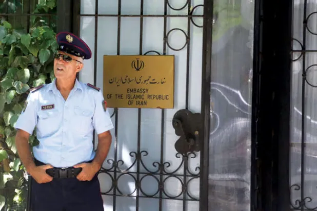 شرطي ألباني يقف أمام بوابة السفارة الإيرانية في تيرانا أمس (أ.ف.ب)