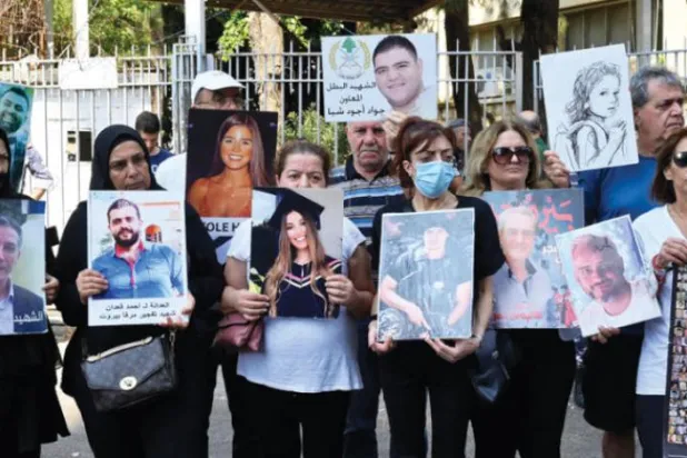 Relatives of some of the victims of the August 2020 Beirut port blast carry their pictures and banners during a protest outside the Justice Palace, in Beirut, Lebanon September 7, 2022 (EPA)
