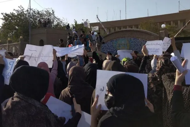 أفغانيات يتظاهرن أمام أعضاء من حركة «طالبان» في هرات (أرشيفية - رويترز)