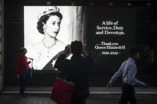 یادگاری مردم در کنار عکس پرتره ملکه الیزابت دوم در لندن (AP)
