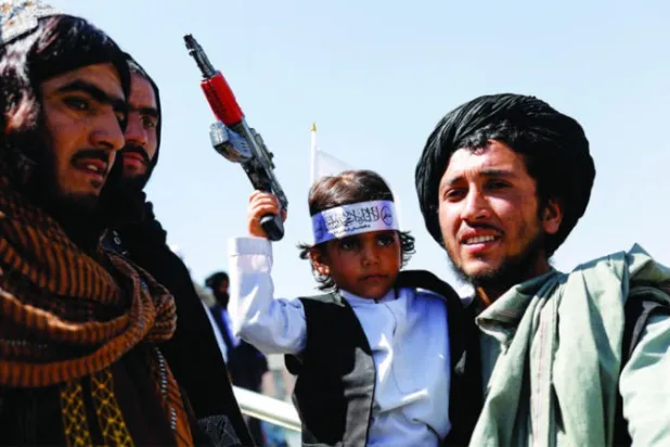 عضو في «طالبان» يحمل ابنه في الذكرى الأولى لانسحاب القوات الأميركية من أفغانستان  في أحد شوارع العاصمة كابل 31 أغسطس 2022 (رويترز)