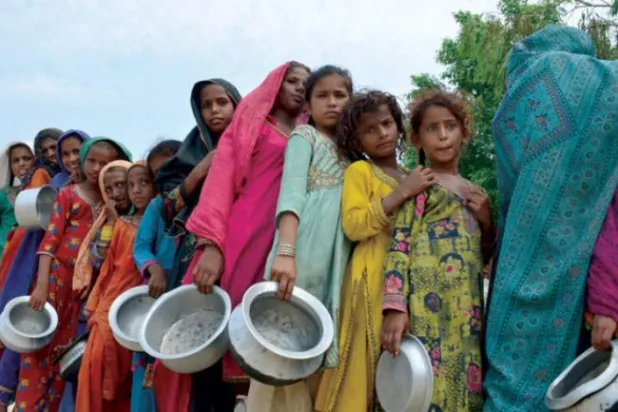 تصویر میں، گزشتہ روز صوبہ سندھ کے ضلع سیہون میں بے گھر افراد کھانے کا راشن لینے کے لیے قطار میں کھڑے ہیں (اے ایف پی)