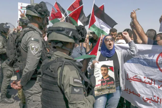 جنود إسرائيليون في مواجهة متظاهرين فلسطينيين قرب رام الله، أمس (أ.ف.ب)