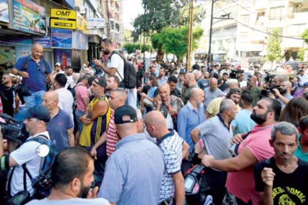 Lebanese gathered in front of a bank branch in Beirut in support of a depositor who stormed the institution to demand his money (EPA)
