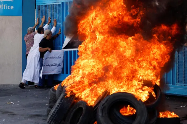 إطارات تحترق خارج مقر «أونروا» الاثنين في غزة (رويترز)