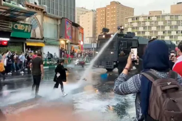 گزشتہ روز مرکزی تہران کے ولی عصر اسکوائر میں مظاہرین کو فسادات کی پولیس کی کار پر پتھر پھینکتے ہوئے دیکھا جا سکتا ہے (ٹویٹر)